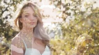 A glamorous woman has an intimate moment with nature on a balcony