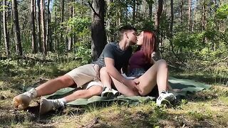 Passionate amateur couple makes love in the park during a picnic