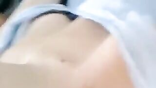 A half-naked girl is lying on the bed and caressing her body