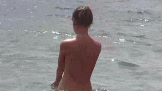 A group of nudists enjoy the beautiful sunny day on the beach