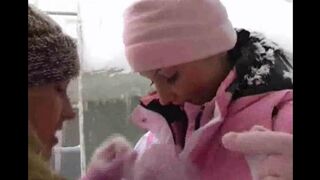 Two girls have fun on a cold winter day, exploring each other