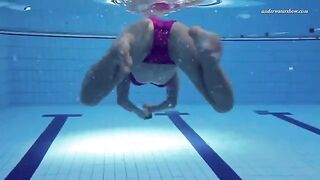A beautiful naked woman is swimming in the pool