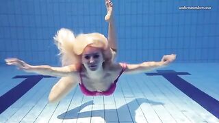 A beautiful naked woman is swimming in the pool