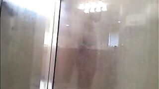 A guy washes his body with a hidden camera in the shower