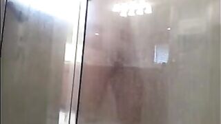 A guy washes his body with a hidden camera in the shower