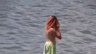 Nudist paradise in Crimea. A girl is walking naked on the coast