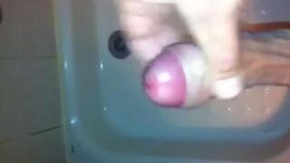 The kid masturbates his dick under a shower jet