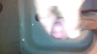 The kid masturbates his dick under a shower jet