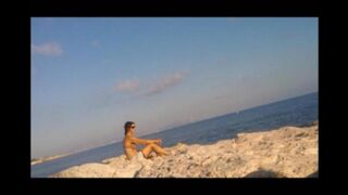 A young girl sunbathes naked on the beach. It's not every day