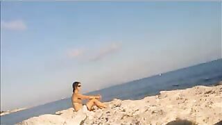 A young girl sunbathes naked on the beach. It's not every day