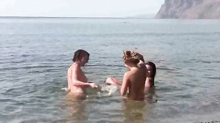 A group of people has no clothes on the beach and plays freely